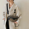 A woman wearing a beige coat and black top holds a leopard print crossbody shoulder bag.
