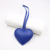 A small blue PU leather heart keychain attached to a white rolled object.