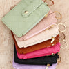 A stack of five pastel quilted PU leather card holder wallets in mint green, pink, beige, brown, and purple with gold-toned b