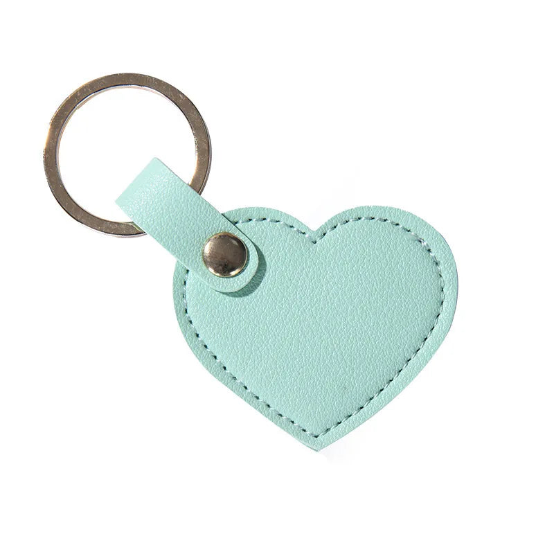 A light mint green leather heart-shaped keychain with a metal ring and clasp.
