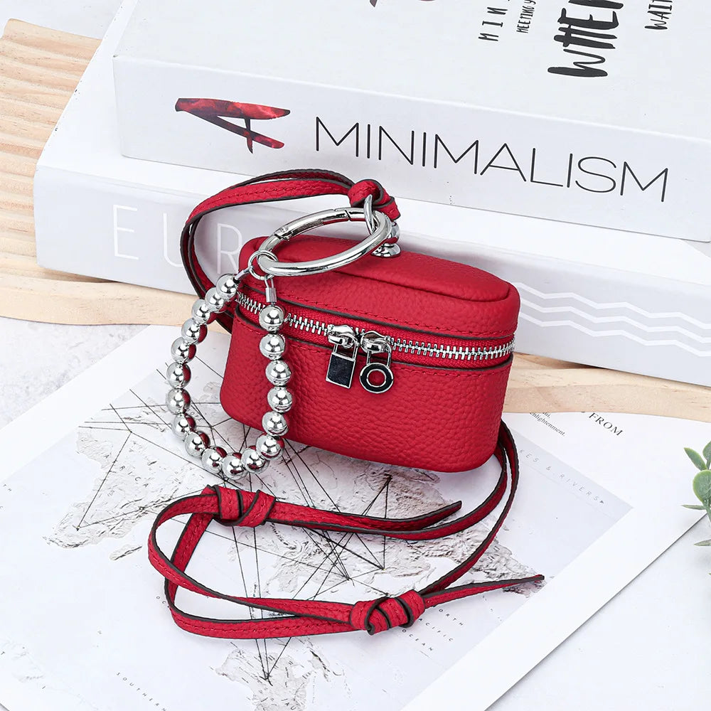 A red leather coin purse with a silver chain and lanyard is displayed on a white background.