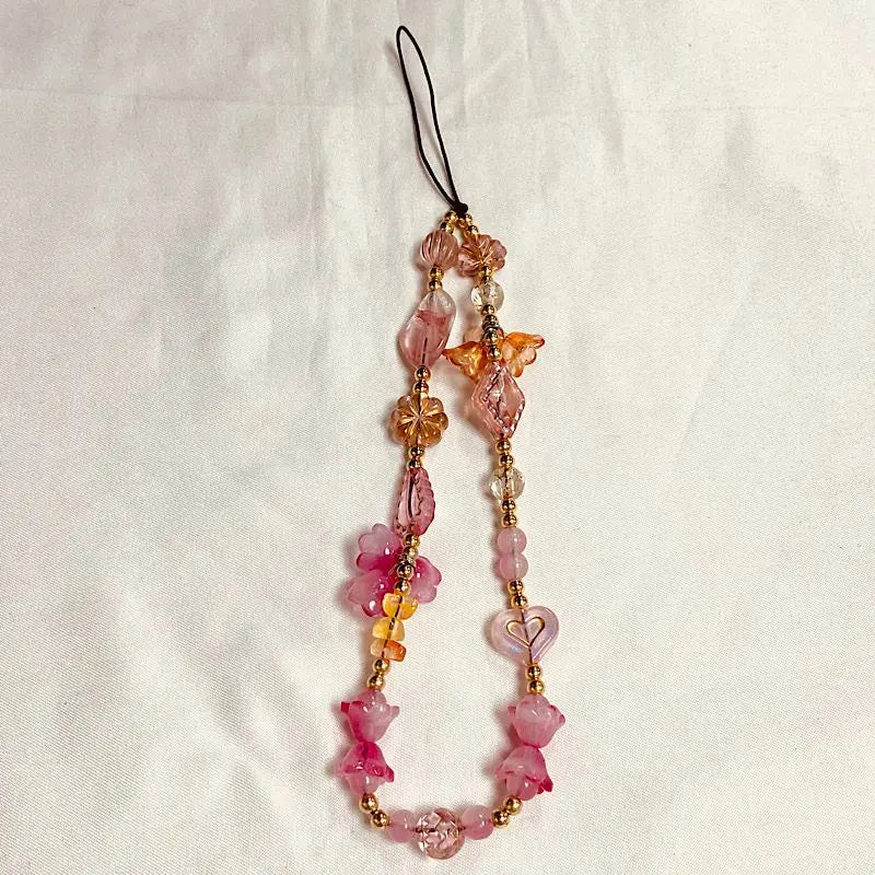 A delicate beaded phone charm strap with anti-lost lanyard featuring pink and amber gemstone beads.