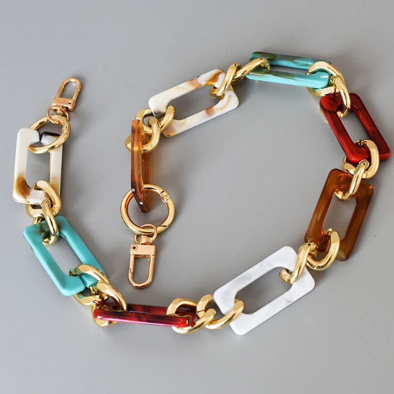 A multi-color acrylic chain strap featuring segments of gold, copper, green, and reddish-brown.
