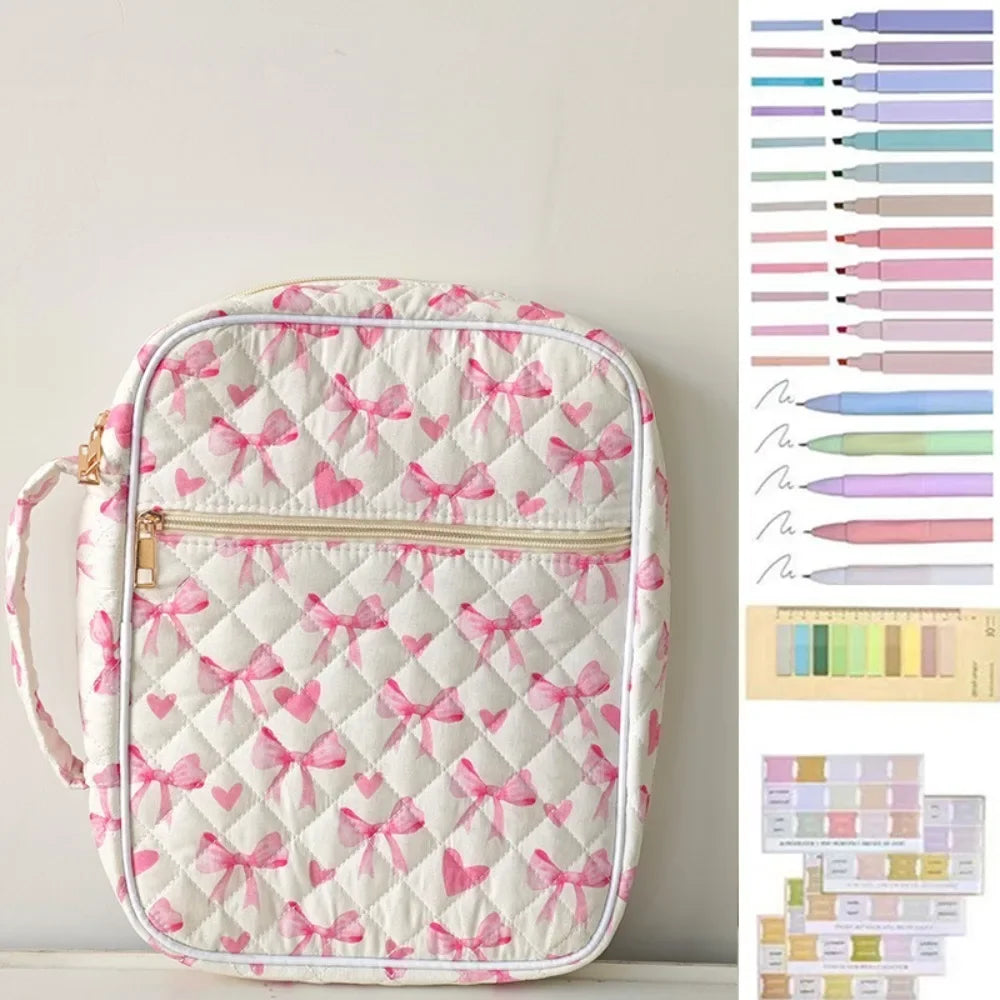 A white quilted floral bible cover with pink bows and a zippered pen holder is displayed against a light background.