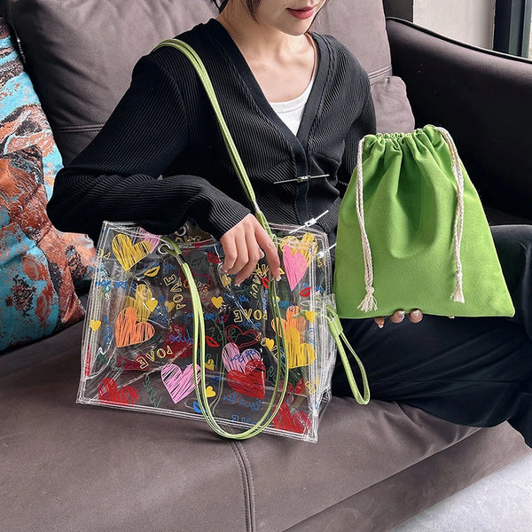 A woman holds a clear plastic bag with colorful fabric and a green drawstring pouch on her lap.