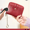 A hand holds a red RFID protected wallet with a zipper closure attached to a chain, emphasizing theft protection.