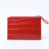 A red crocodile pattern leather card holder with a zipper on a white background.