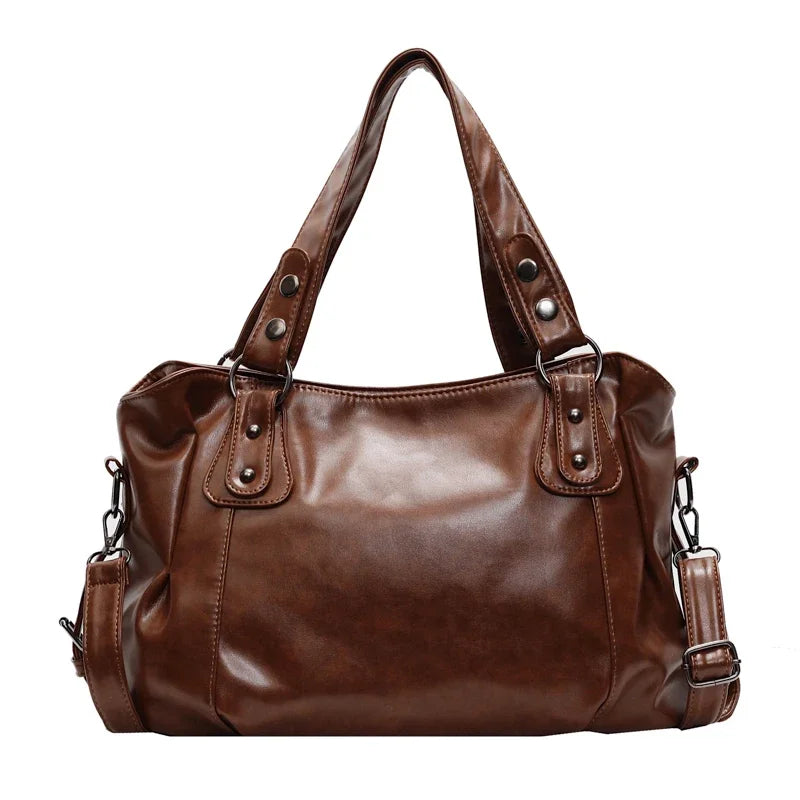 A brown vintage style leather tote bag with a crossbody strap.