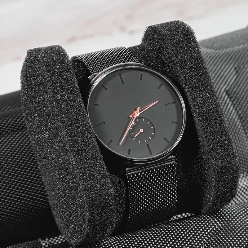 A black leather watch organizer travel case holding a rose gold analog watch.