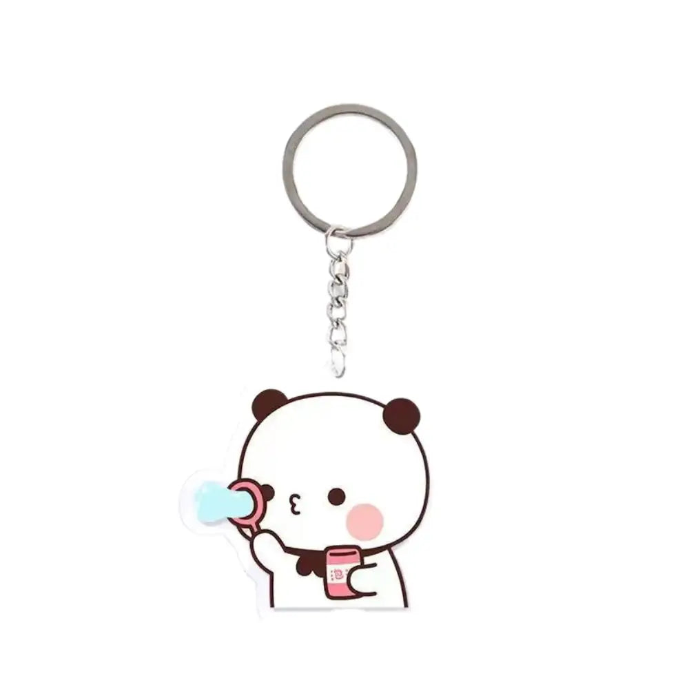 A white cartoon panda character holding a pink cup charm attached to a silver keyring.
