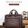 A brown genuine leather men's briefcase with brass hardware resting on a wooden surface.