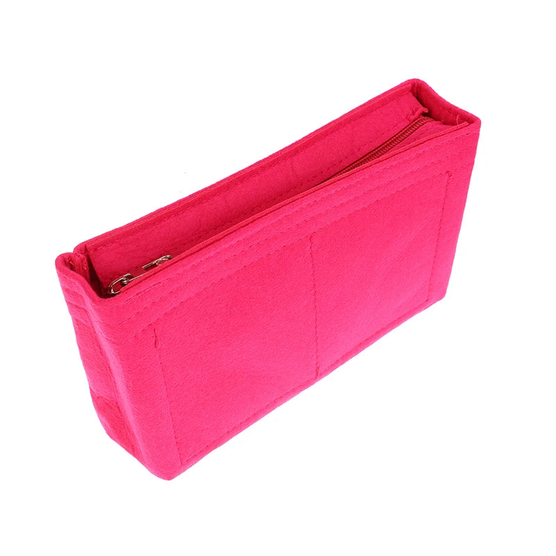 A bright pink felt cosmetic bag insert organizer with a zippered closure.