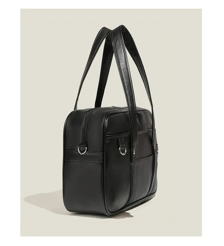 Black Japanese style student messenger bag made of waterproof PU leather with adjustable shoulder straps.