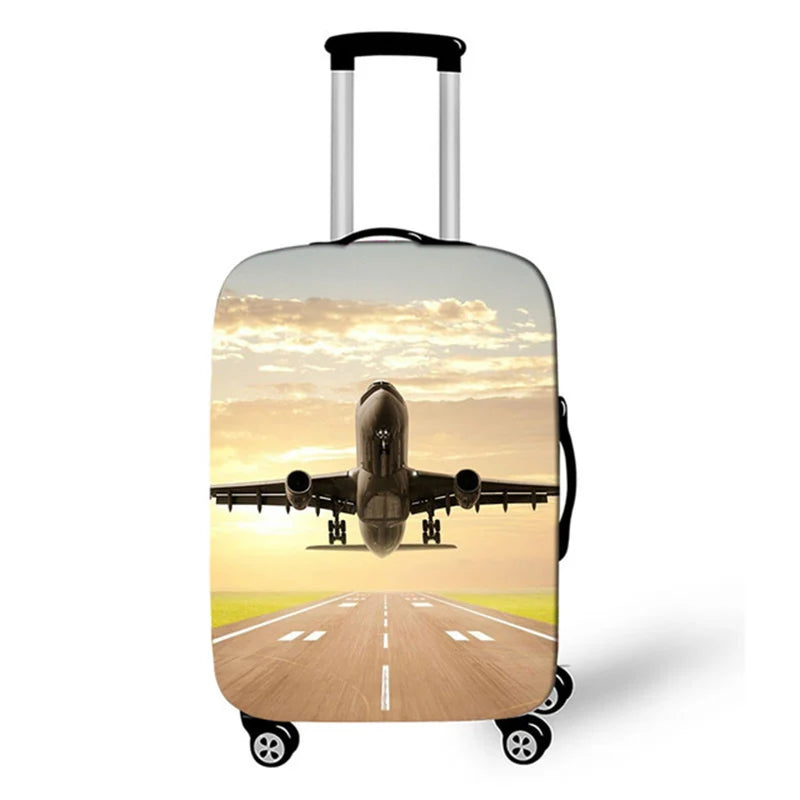 A silver rolling suitcase with a graphic of an airplane taking off over a sunset road.