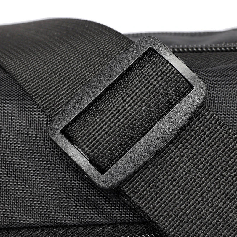 Close-up of a black nylon shoulder bag featuring a rectangular strap detail.