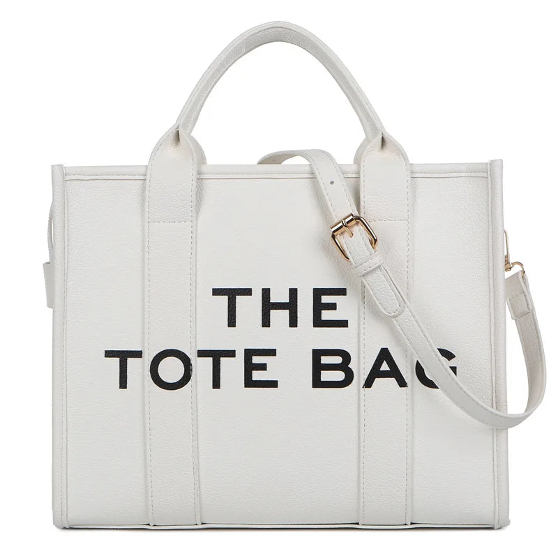 Sac cabas de luxe blanc de designer avec texte noir indiquant 'THE TOTE BAG'