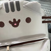 A white canvas backpack featuring a cute Pusheen cat face design with dark brown markings and eyes.