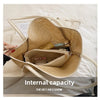 A straw woven tote bag with PU trim and a matching inner pouch is shown resting on a light-colored fabric.
