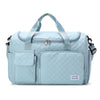Light blue quilted portable travel duffle bag with shoulder straps and exterior pockets