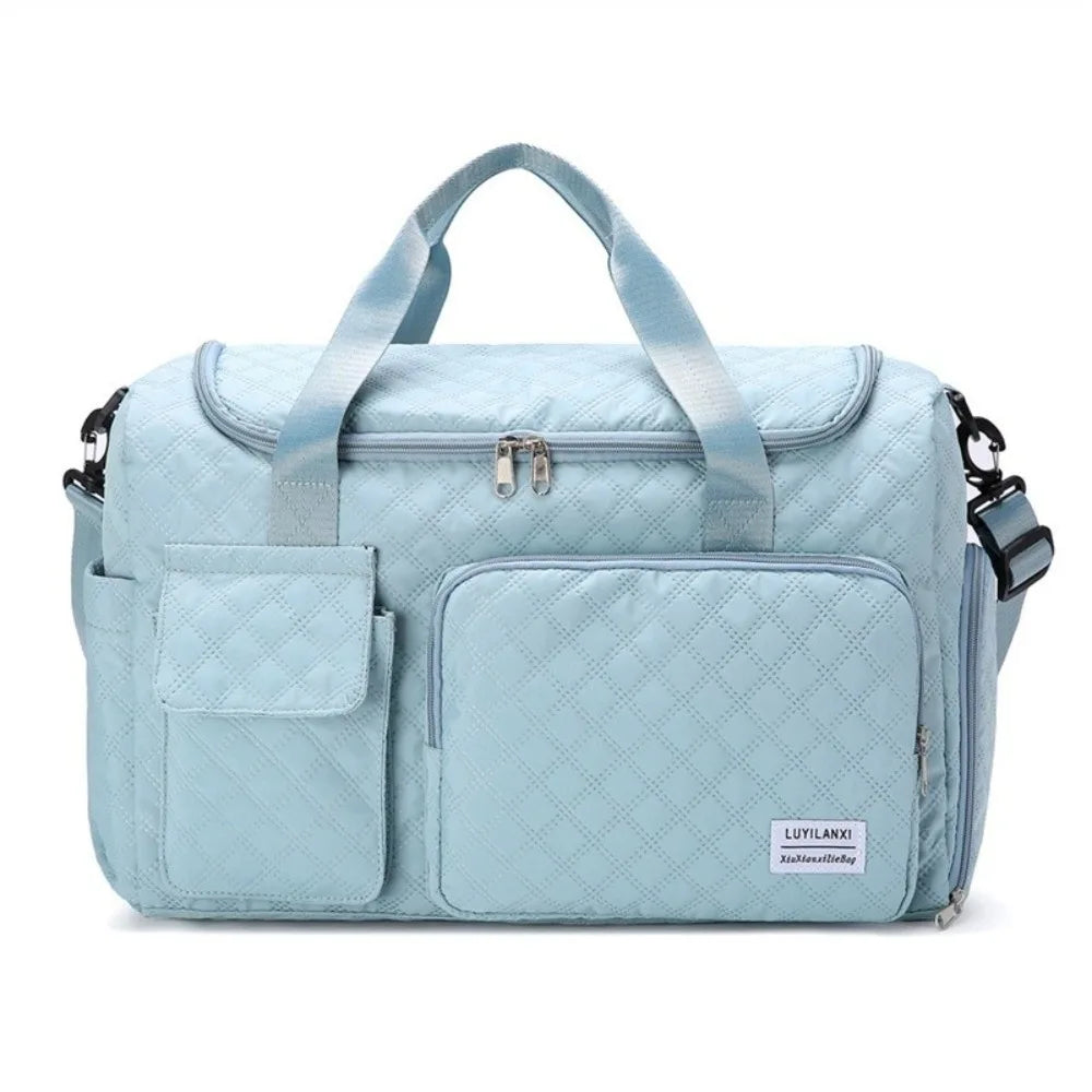 Light blue quilted portable travel duffle bag with shoulder straps and exterior pockets