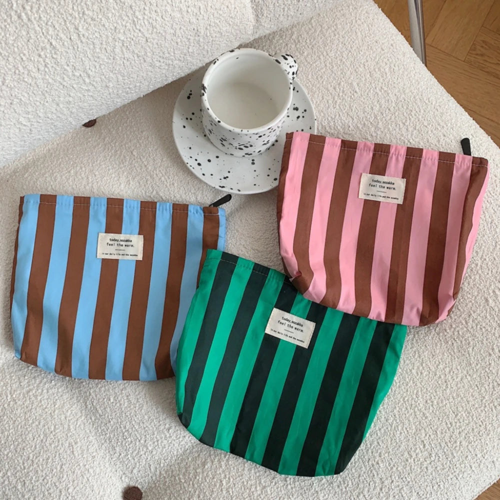 Tres fundas de almacenamiento de lienzo con patrones a rayas, incluyendo azules y marrones, rosas y verdes.