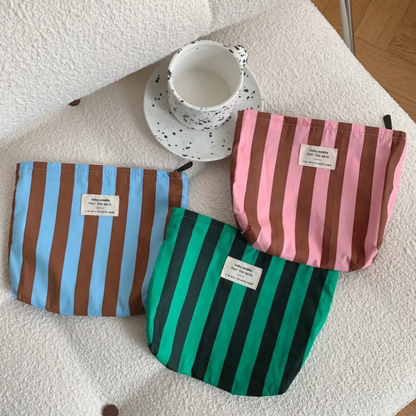 Three canvas storage pouches in striped patterns, including blue and brown stripes, pink stripes, and green stripes.
