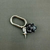 A silver-toned keychain featuring a black and white dice charm with a star pendant.