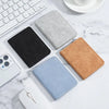 A collection of leather and fabric card wallets in black, gray, and tan colors arranged on a white marble surface.