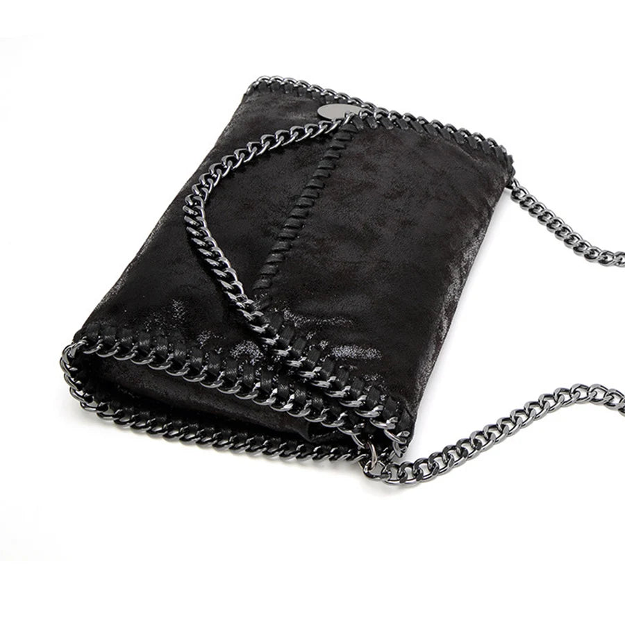 Black velvet flap crossbody bag with a silver chain strap