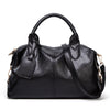 A black faux leather Boston handbag with a top handle and shoulder strap is shown against a white background.