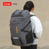 A large gray travel backpack is shown being carried by a person against a light background.