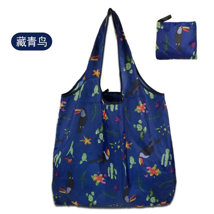 A dark blue reusable eco tote shopping bag featuring a pattern of colorful leaves and plants.