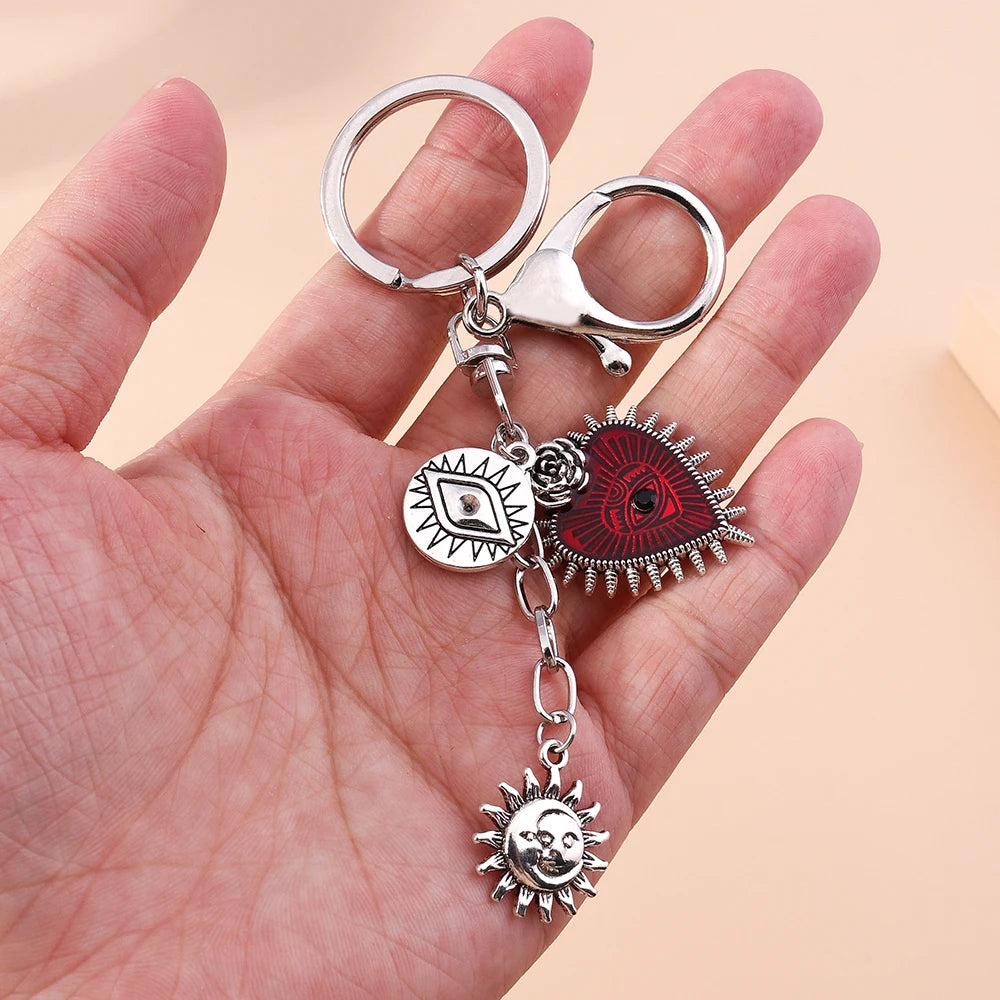 Silver gothic steampunk heart keychain featuring a sun eye pendant and a sun charm
