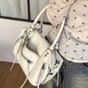 A white vintage PU leather crossbody tote bag with a silver zipper and adjustable strap being held by a person.