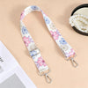 A floral patterned nylon crossbody bag strap with a silver metal buckle is displayed on a light background.