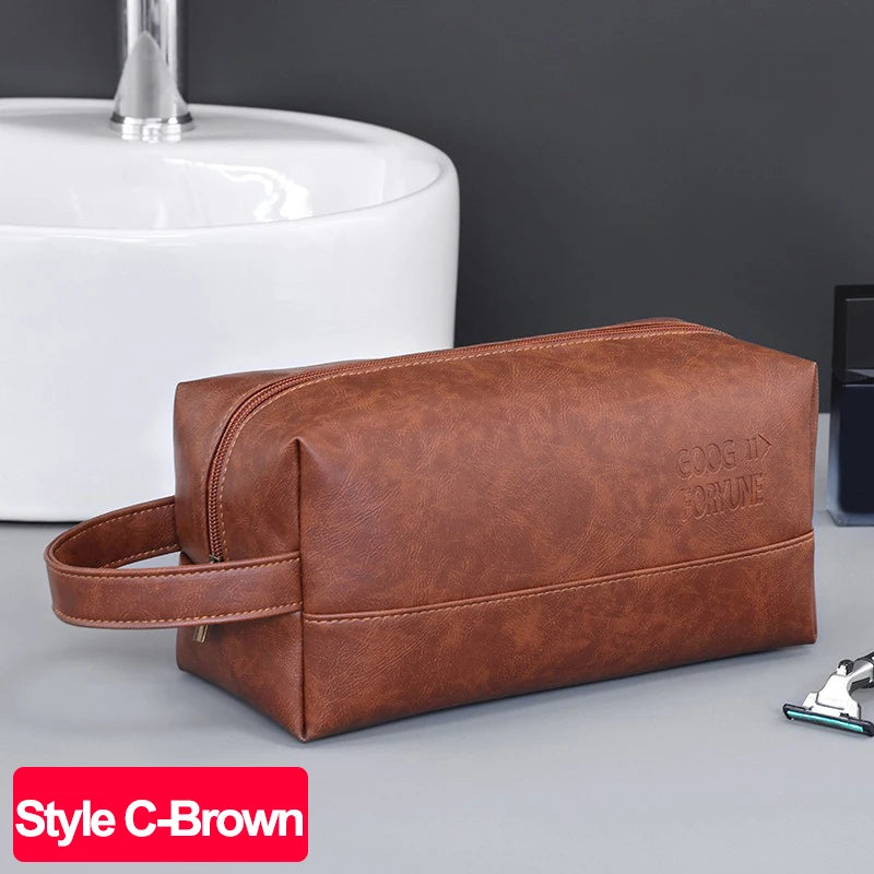 A brown PU leather toiletry bag resting on a gray surface next to a white ceramic sink.