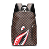 A brown and black checkered plaid laptop backpack featuring a stylized shark mouth design.