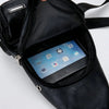 Sac bandoulière en cuir noir à fermeture éclair ouverte, révélant un smartphone à l'intérieur.