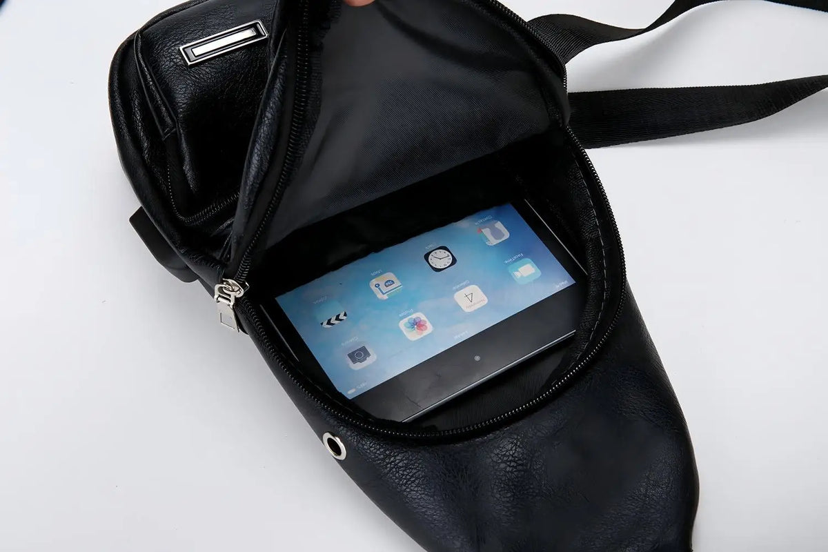 Sac bandoulière en cuir noir à fermeture éclair ouverte, révélant un smartphone à l'intérieur.