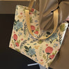 A beige bohemian corduroy tote bag with floral embroidery is shown hanging on a hanger.