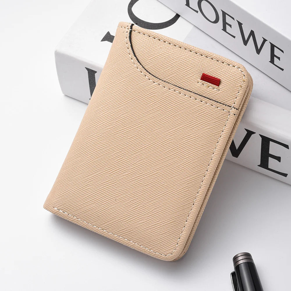A light beige slim bi-fold wallet for men resting on a white surface next to some books.