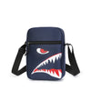 Pochette de téléphone crossbody bleu foncé avec motif dent de requin stylisé et sangle noire ajustable.