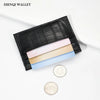 Black crocodile pattern slim card holder wallet with several light-colored cards and a silver coin