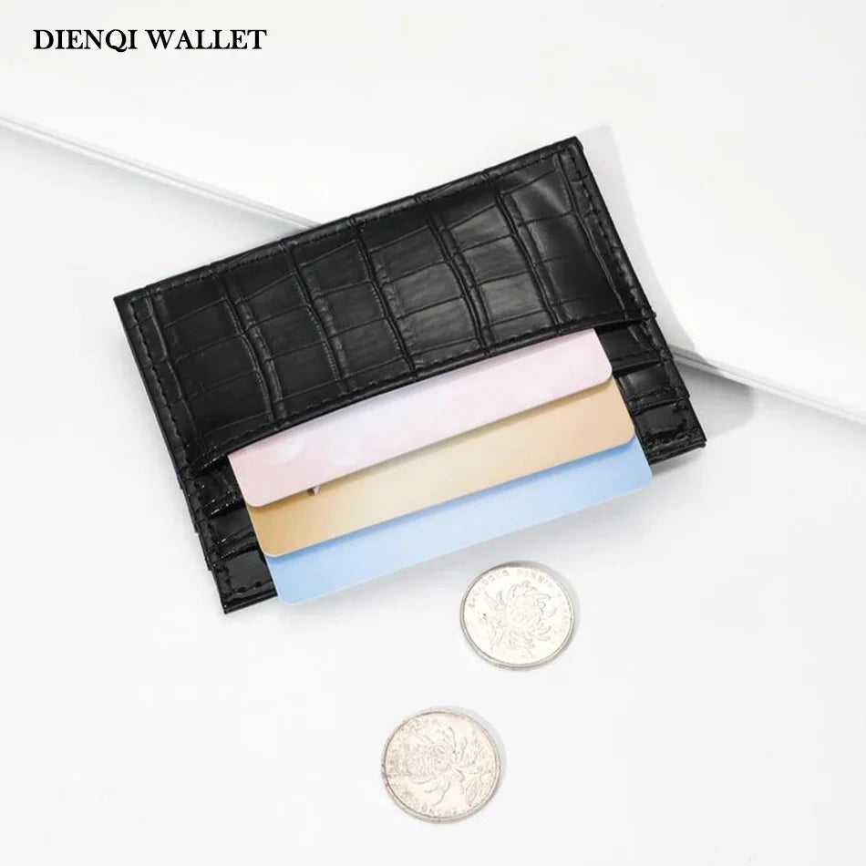 Black crocodile pattern slim card holder wallet with several light-colored cards and a silver coin