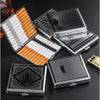 A collection of decorative metal cigarette storage boxes and cylindrical tobacco containers are displayed on a dark surface.