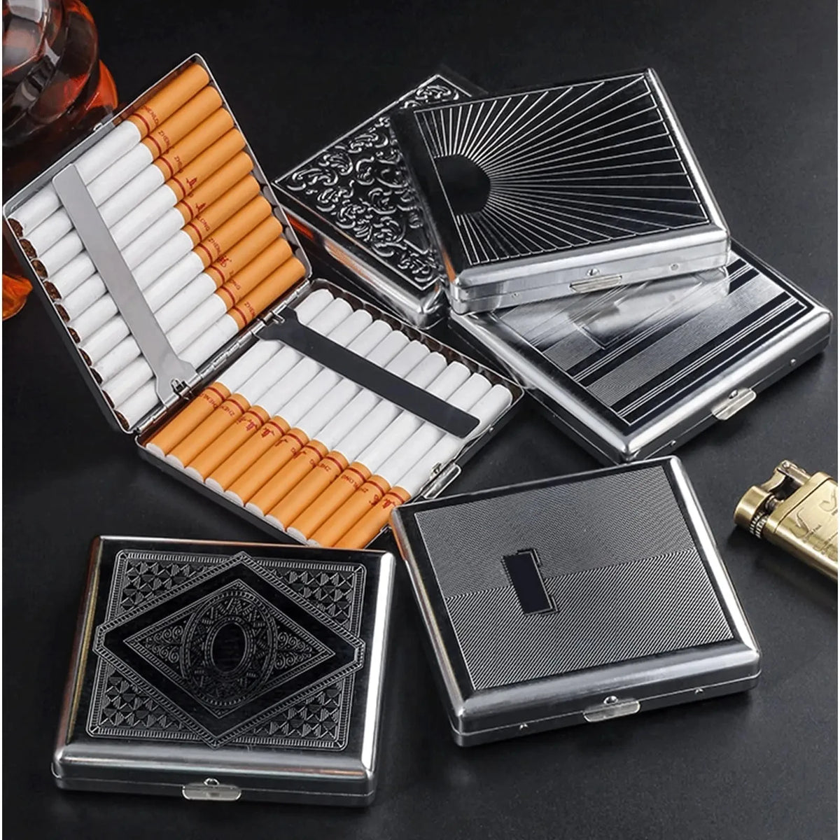 A collection of decorative metal cigarette storage boxes and cylindrical tobacco containers are displayed on a dark surface.