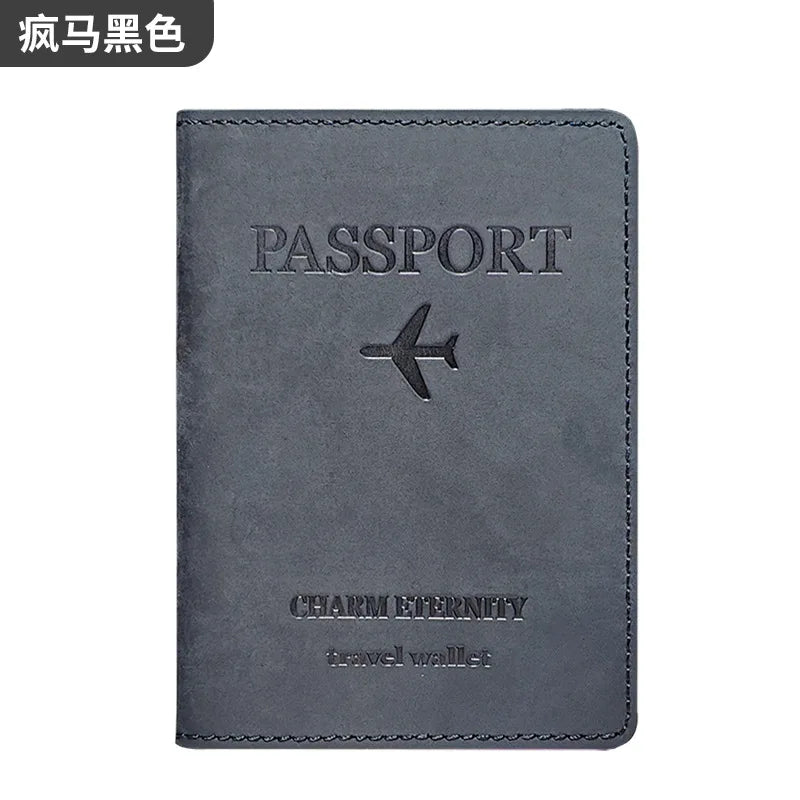 A dark gray genuine leather passport holder and travel wallet with a silver airplane emblem.