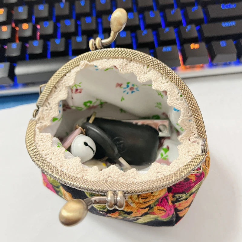 A vintage rose print canvas coin purse is shown open, revealing a dark object and a white marble.