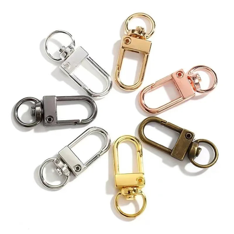 Eine Sammlung von Metall-Scharnierhaken in Gold- und Silber-Optik für Taschen und Gürtel.