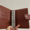 A close-up of a brown leather A7 crocodile ring binder notebook being held open.